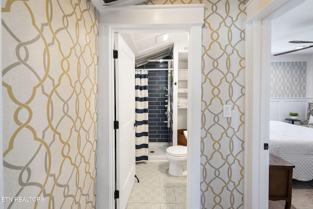 ensuite bathroom featuring wallpapered walls, wainscoting, toilet, ensuite bathroom, and curtained shower