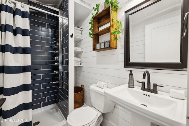 full bath featuring a stall shower, a sink, and toilet