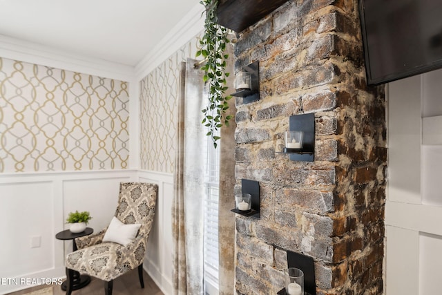 interior space with a decorative wall, crown molding, and wainscoting