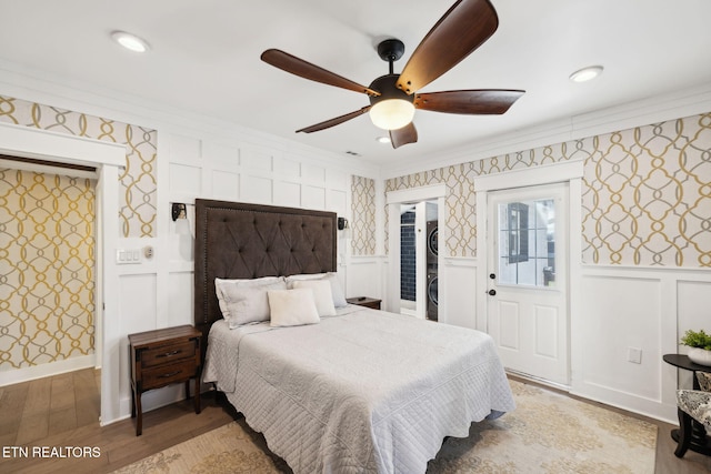 bedroom featuring a wainscoted wall, light wood-style flooring, and wallpapered walls