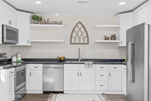 kitchen featuring open shelves, a sink, white cabinets, and stainless steel appliances