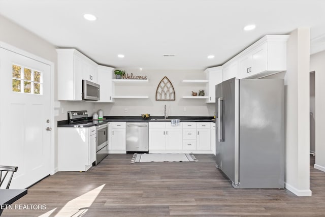 kitchen with open shelves, appliances with stainless steel finishes, dark wood-type flooring, and dark countertops