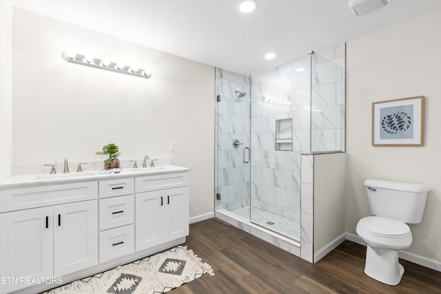 full bathroom featuring toilet, a stall shower, a sink, and wood finished floors