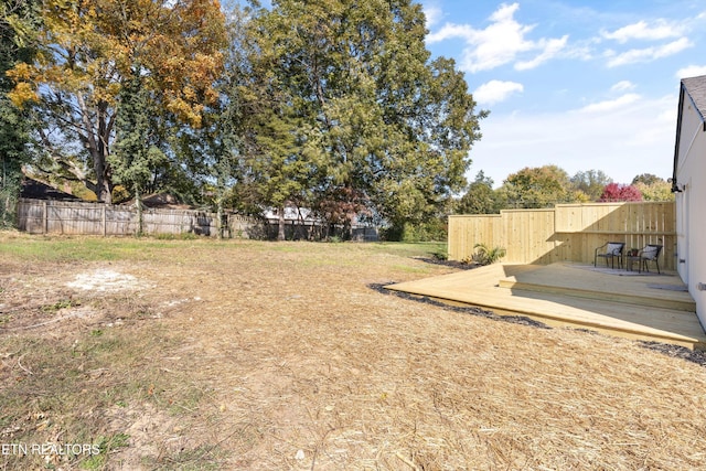 view of yard with fence and a deck