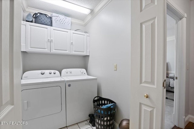 laundry area featuring cabinet space, washer and clothes dryer, and crown molding