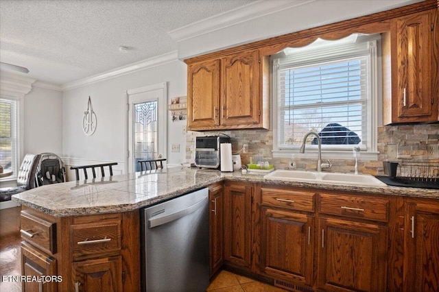 kitchen with a wealth of natural light, dishwasher, a peninsula, and a sink