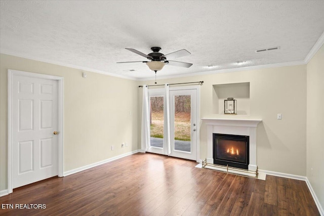 unfurnished living room featuring a glass covered fireplace, visible vents, crown molding, and wood finished floors