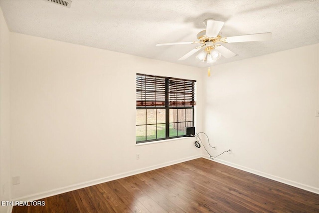 spare room with dark wood-style floors, a textured ceiling, baseboards, and a ceiling fan