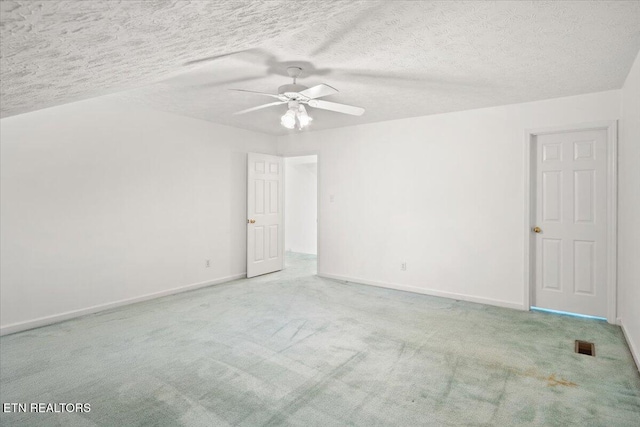 unfurnished room featuring baseboards, visible vents, a ceiling fan, a textured ceiling, and carpet floors