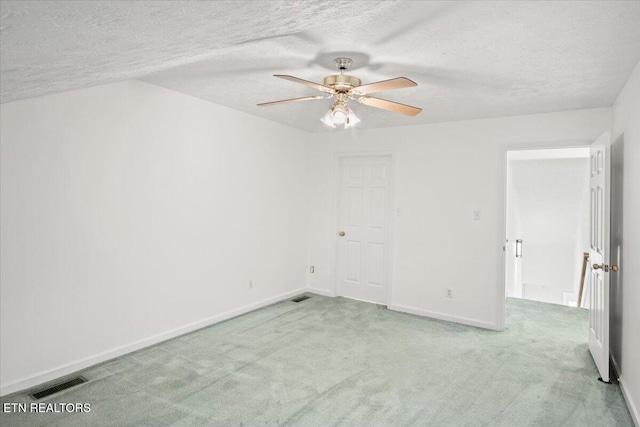 spare room with baseboards, visible vents, ceiling fan, a textured ceiling, and carpet floors