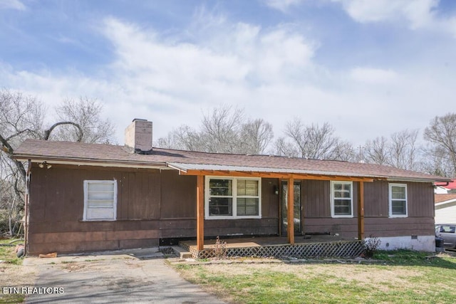 view of front of house with a porch, a shingled roof, crawl space, a front lawn, and a chimney