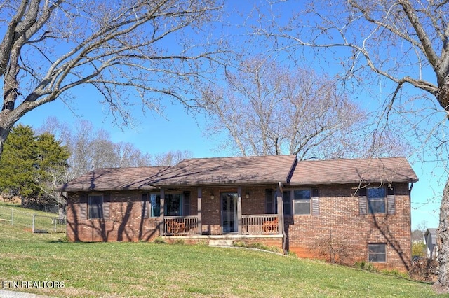 ranch-style home featuring a porch, a front yard, and brick siding