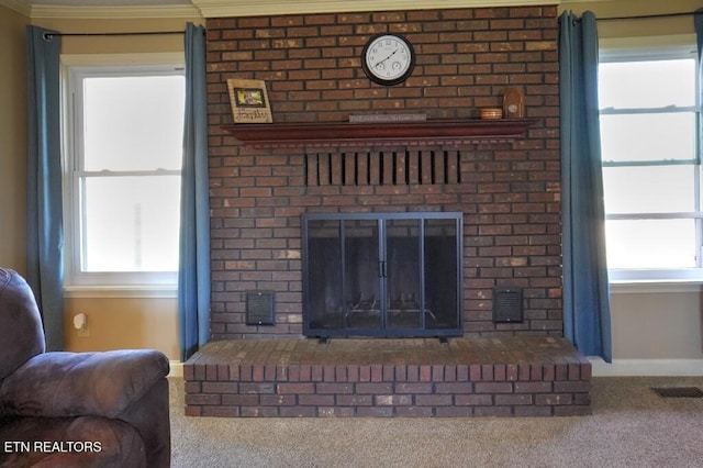 carpeted living area featuring baseboards, a fireplace, visible vents, and crown molding