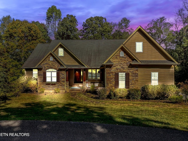 craftsman-style house with stone siding and a front yard