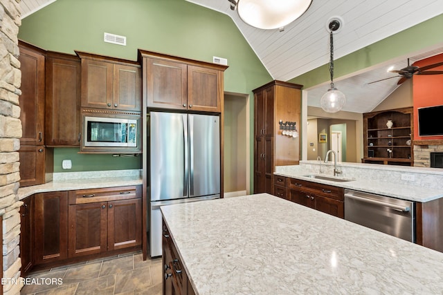 kitchen featuring decorative light fixtures, lofted ceiling, stainless steel appliances, a ceiling fan, and a sink