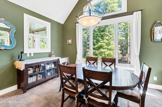 dining area with plenty of natural light, baseboards, and vaulted ceiling