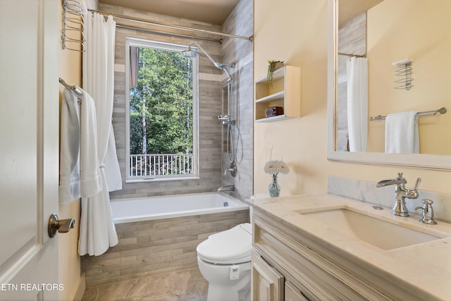 bathroom with vanity, toilet, and tiled shower / bath combo