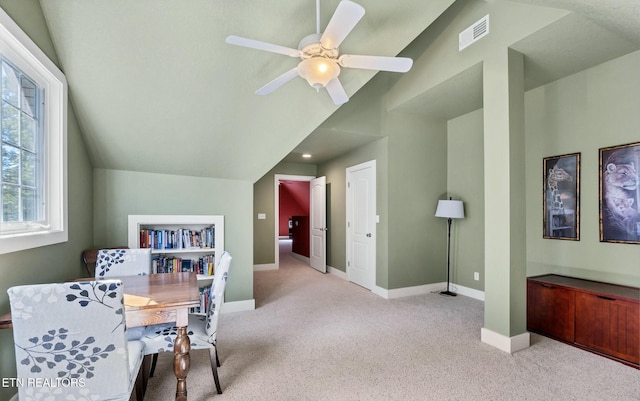 carpeted office space featuring visible vents, baseboards, ceiling fan, and vaulted ceiling