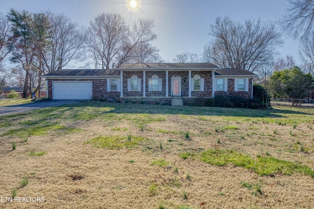 ranch-style home with a front lawn, fence, aphalt driveway, a porch, and an attached garage