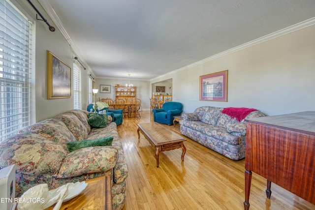 living area with wood-type flooring, a chandelier, and ornamental molding