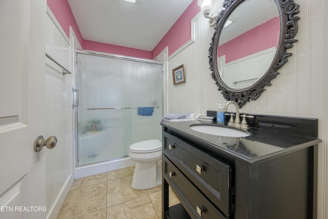 bathroom with toilet, a stall shower, vanity, and tile patterned flooring