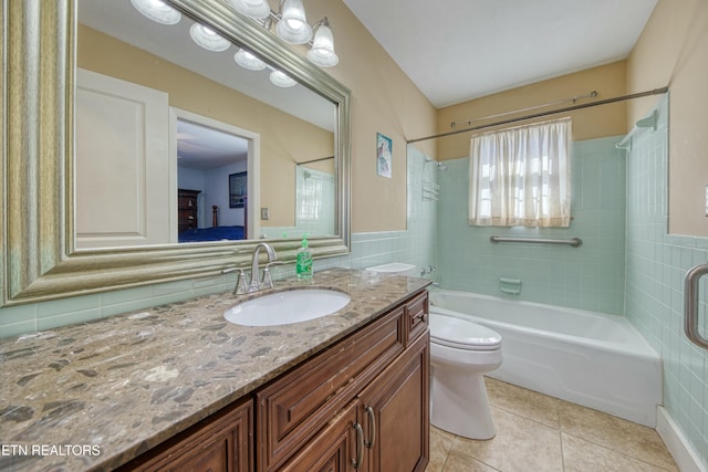 bathroom featuring vanity,  shower combination, tile patterned flooring, tile walls, and toilet