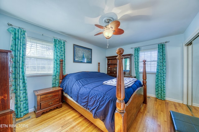 bedroom featuring visible vents, multiple windows, and wood finished floors