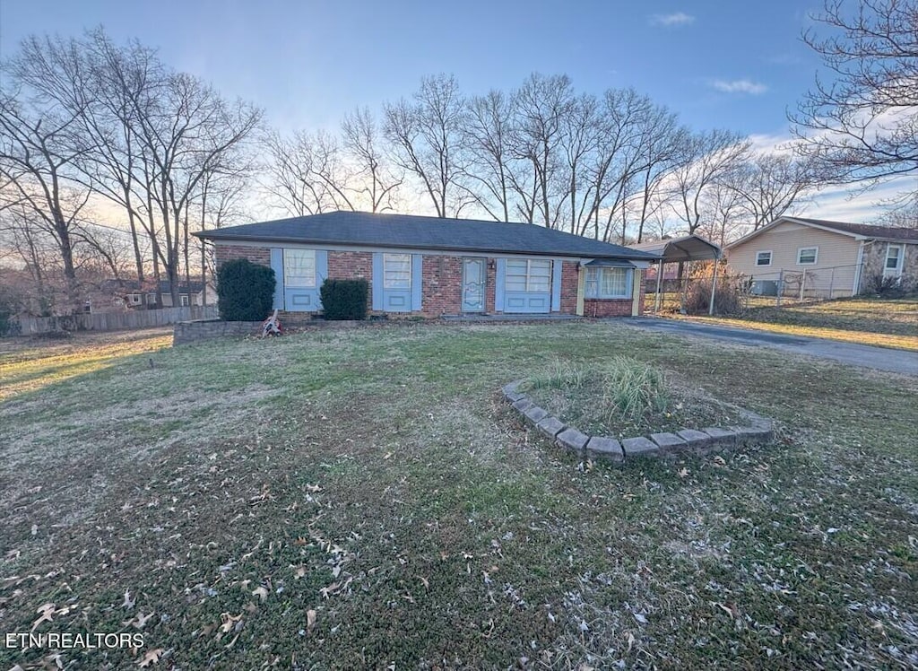 view of front facade featuring a front yard, fence, and brick siding