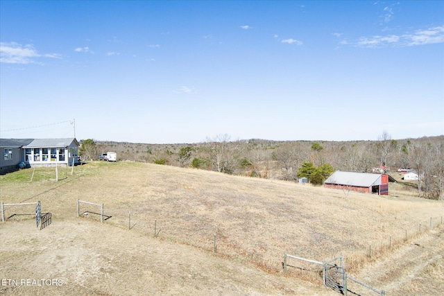 view of yard with an outbuilding, a rural view, and fence