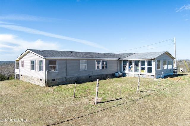 rear view of property with a sunroom, crawl space, and a yard