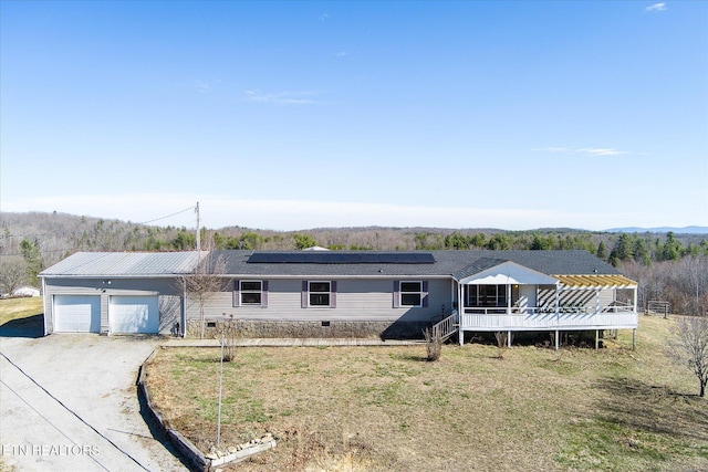 view of front of property featuring a garage, solar panels, crawl space, and driveway