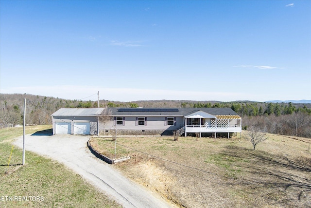 manufactured / mobile home featuring a deck, an attached garage, driveway, crawl space, and roof mounted solar panels