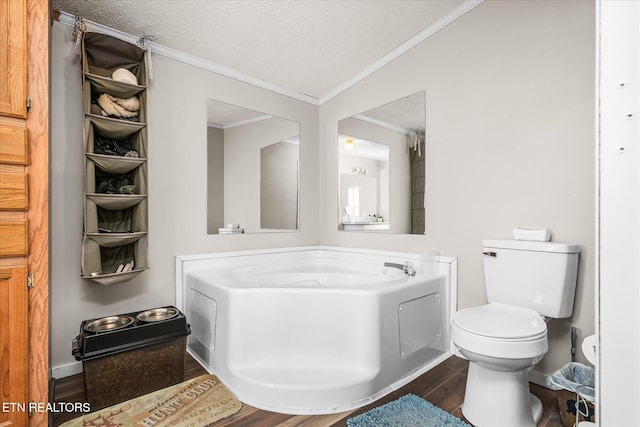 full bath featuring toilet, wood finished floors, crown molding, a textured ceiling, and a bath