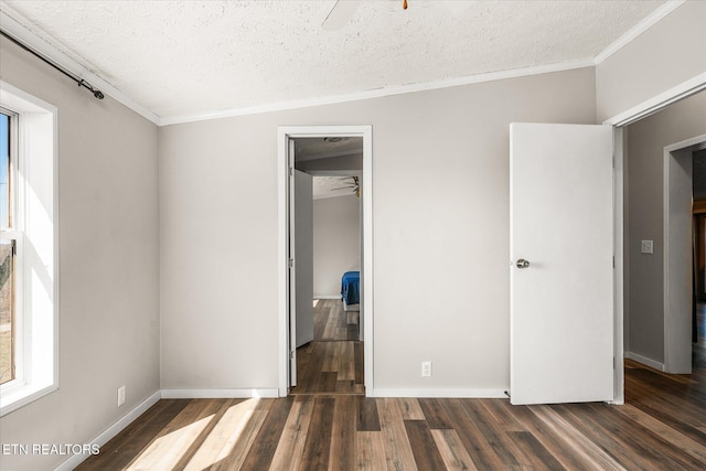 unfurnished bedroom with baseboards, ornamental molding, wood finished floors, a textured ceiling, and a closet