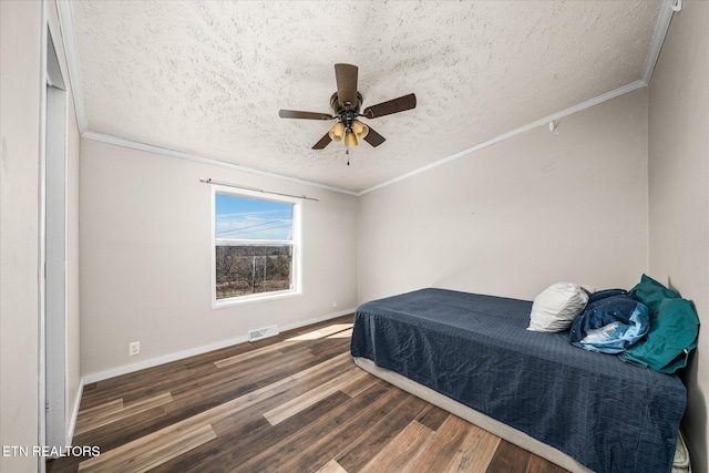 bedroom with a textured ceiling, wood finished floors, visible vents, and crown molding