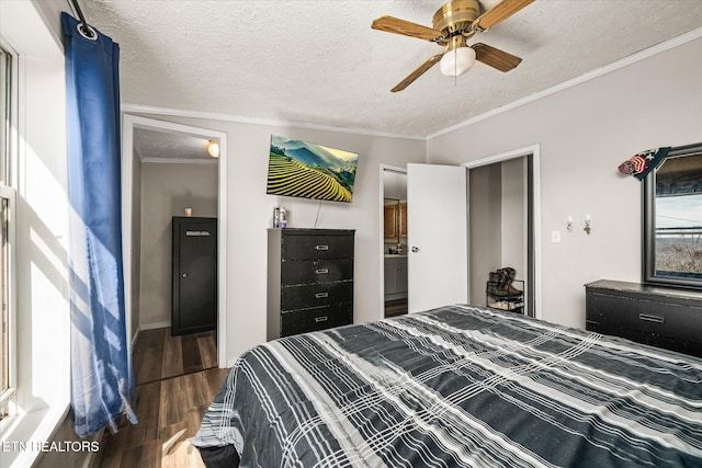 bedroom featuring a textured ceiling, wood finished floors, and crown molding