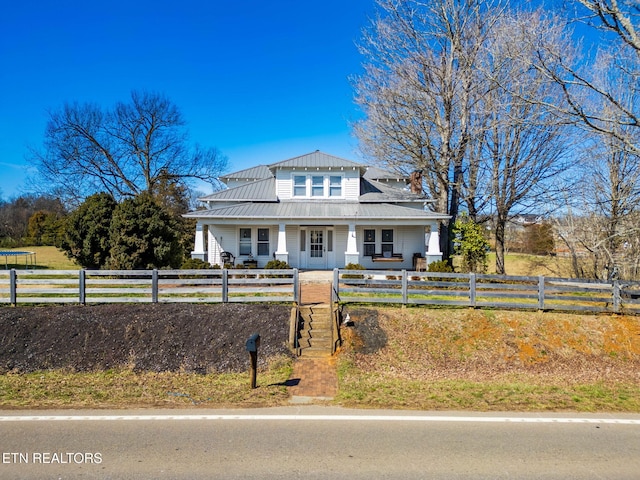 bungalow-style house with metal roof, a porch, a fenced front yard, and a gate