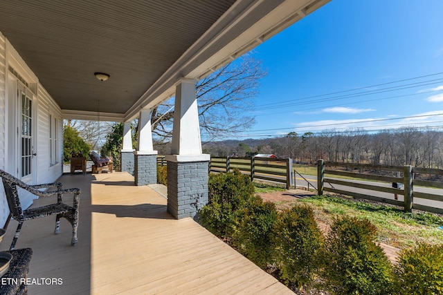 wooden terrace with a porch and fence