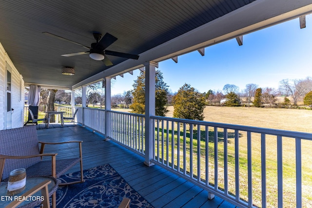 wooden deck with a ceiling fan and a yard