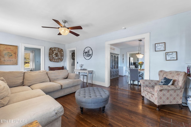 living room featuring ceiling fan, baseboards, and wood finished floors