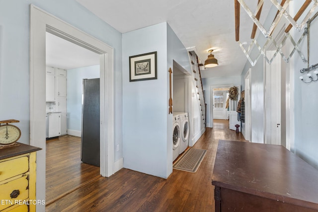 washroom with laundry area, washing machine and dryer, and dark wood-style flooring