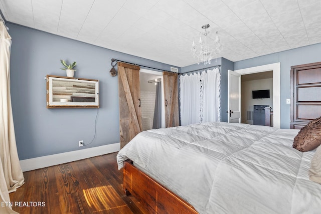 bedroom featuring an inviting chandelier, baseboards, and wood finished floors