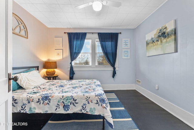 bedroom featuring a ceiling fan, dark wood finished floors, and baseboards