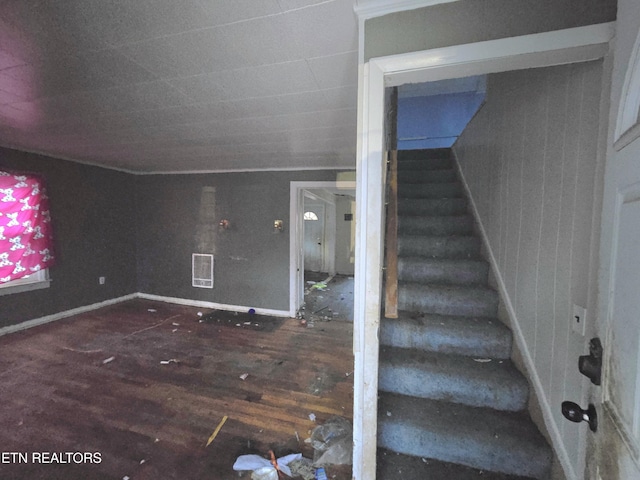 stairway with baseboards, visible vents, and wood finished floors