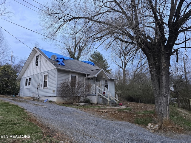 bungalow featuring roof with shingles