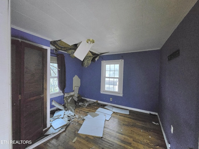 interior space featuring wood-type flooring, vaulted ceiling, and baseboards