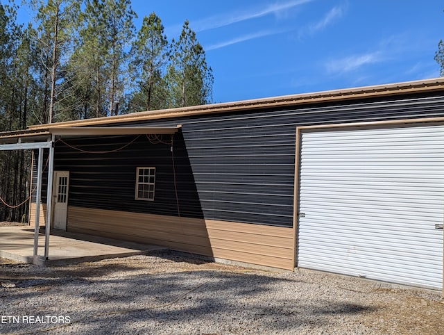 exterior space with a carport, a patio area, and an outdoor structure