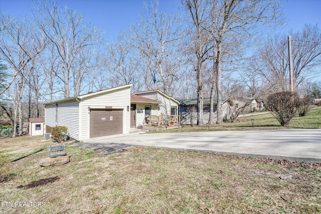 view of home's exterior featuring an outbuilding, concrete driveway, a lawn, and an attached garage