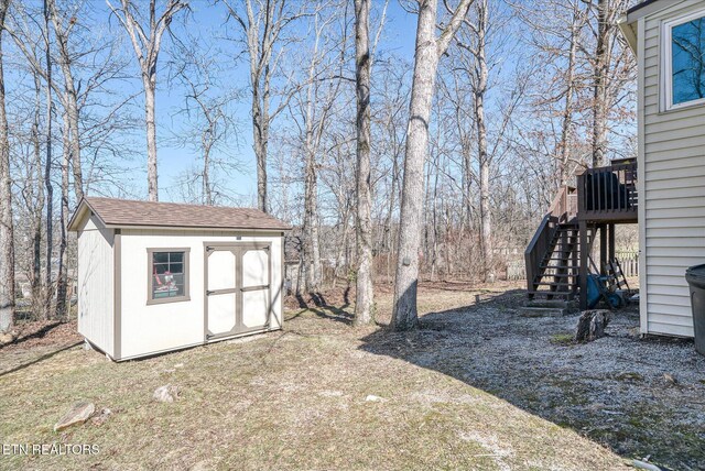 view of yard featuring a shed, stairway, and an outdoor structure