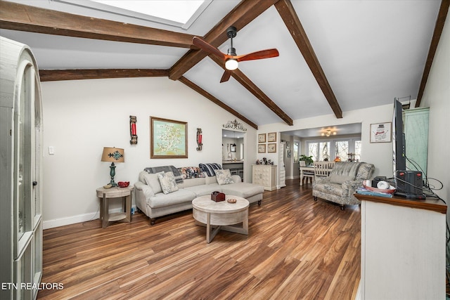 living area featuring lofted ceiling with skylight, ceiling fan, baseboards, and wood finished floors